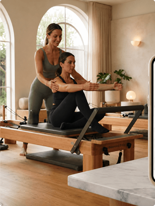 Pilates instructor leading a session on a reformer